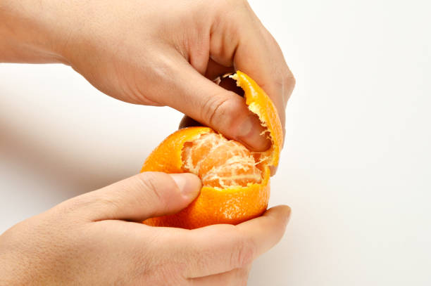 istock Male Hand Peeling a Mandarin 899748908