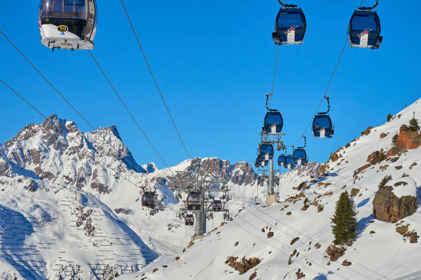 zwei links mono-kabel abnehmbar gondeln mit hoher transportkapazität heben skifahrer auf dem hügel in den tiroler alpen. - dolomites ski lift winter ski track stock-fotos und bilder