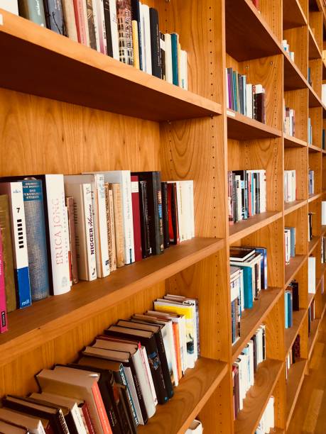 istock Brown wooden shelfs fully packed with books in a library 899751446