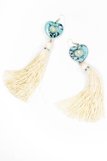 istock Earrings with white thread in gold on a white background 899758368