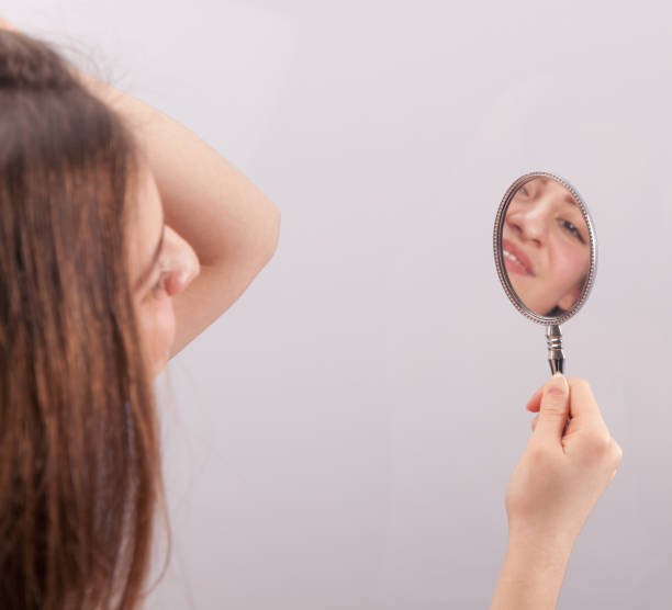 istock Young woman looking mirror 899758688