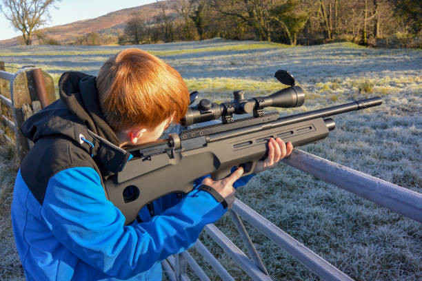 zbliżenie młodego chłopca strzelanie z karabinu pneumatycznego (krajobraz) - air rifle zdjęcia i obrazy z banku zdjęć