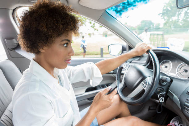 istock Young female driver focuses on road while texting 899764888