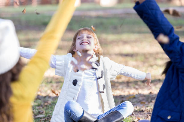 istock Young friends toss leaves on an autumn day 899767372