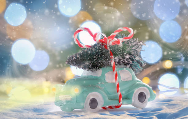 istock toy car carrying a Christmas tree in night time 899768120
