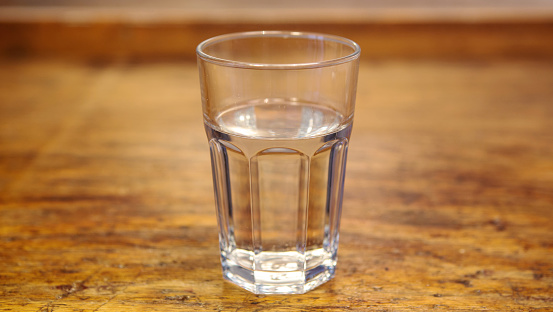 close up of glass with water on rustic wooden table