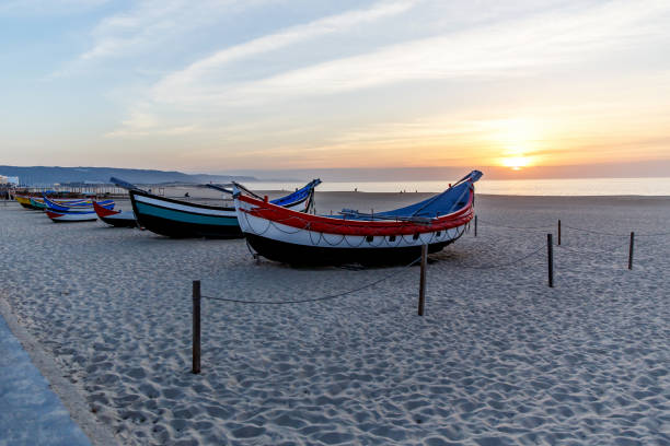 istock fishing boat on the beach at sunset 899779336
