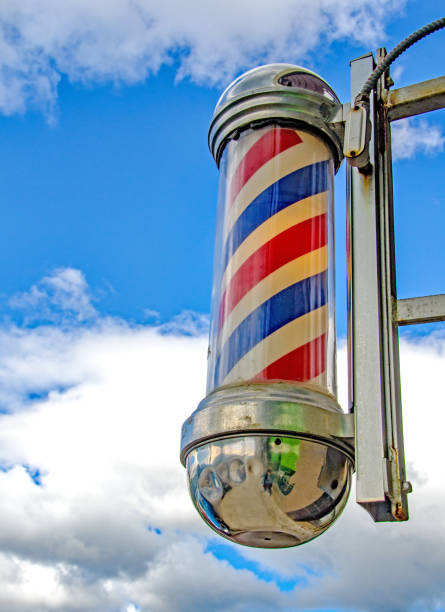 istock Barber's Pole sign in glass against blue sky 899780066
