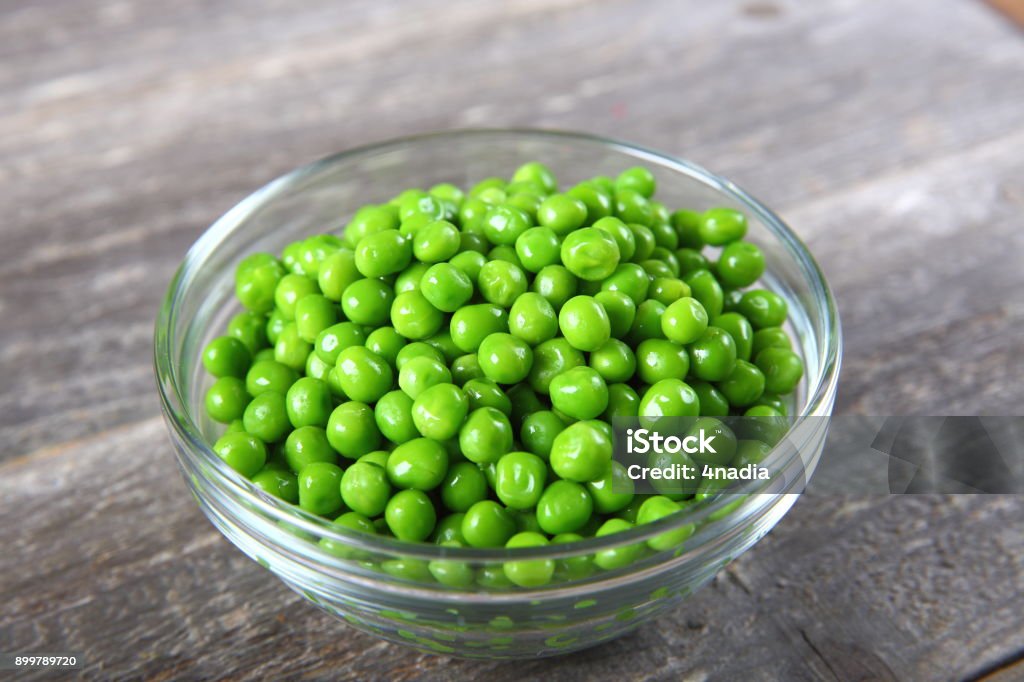 Fresh green peas in a bowl Green Pea Stock Photo