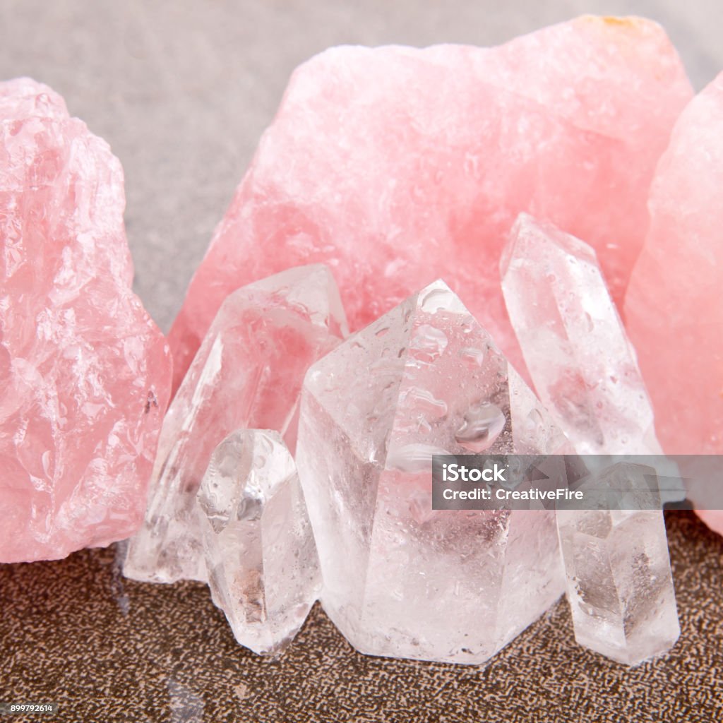 Rose and Clear Quartz healing crystals Rose and Clear Quartz healing crystals on wet brown slate background Rose Quartz Stock Photo