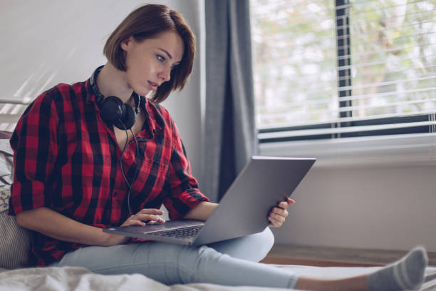 istock Woman using her laptop in the bed 899800470