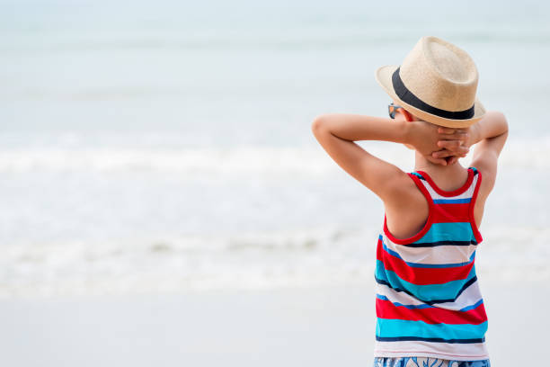 istock Boy in a hat and sunglasses admiring the sea 899800890