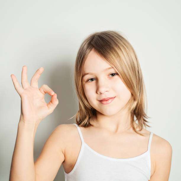 istock Young girl showing her hand gesture ok 899802580