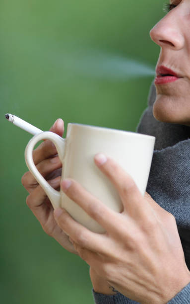istock Beautiful woman smoking a cigarette and drinking coffee 899805482