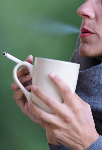 istock Beautiful woman smoking a cigarette and drinking coffee 899809138