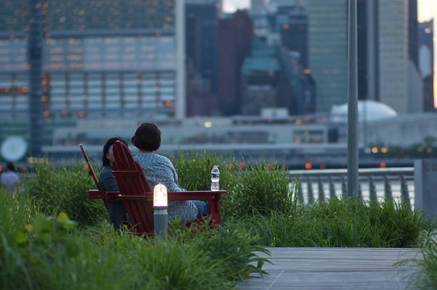 Long Island City, New York. June 16, 2011 - Two guys sitting on the bench facing the skyline of New York.