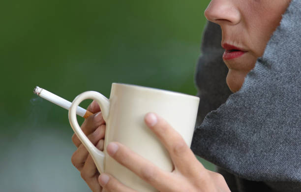 istock Beautiful woman smoking a cigarette and drinking coffee 899819752