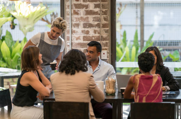 istock Waitress serving to a group of people at a cafe 899827680