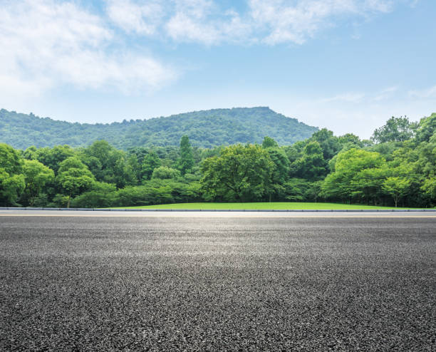 country road and mountains with forest in summer country road and mountains with forest landscape in summer tarmac stock pictures, royalty-free photos & images