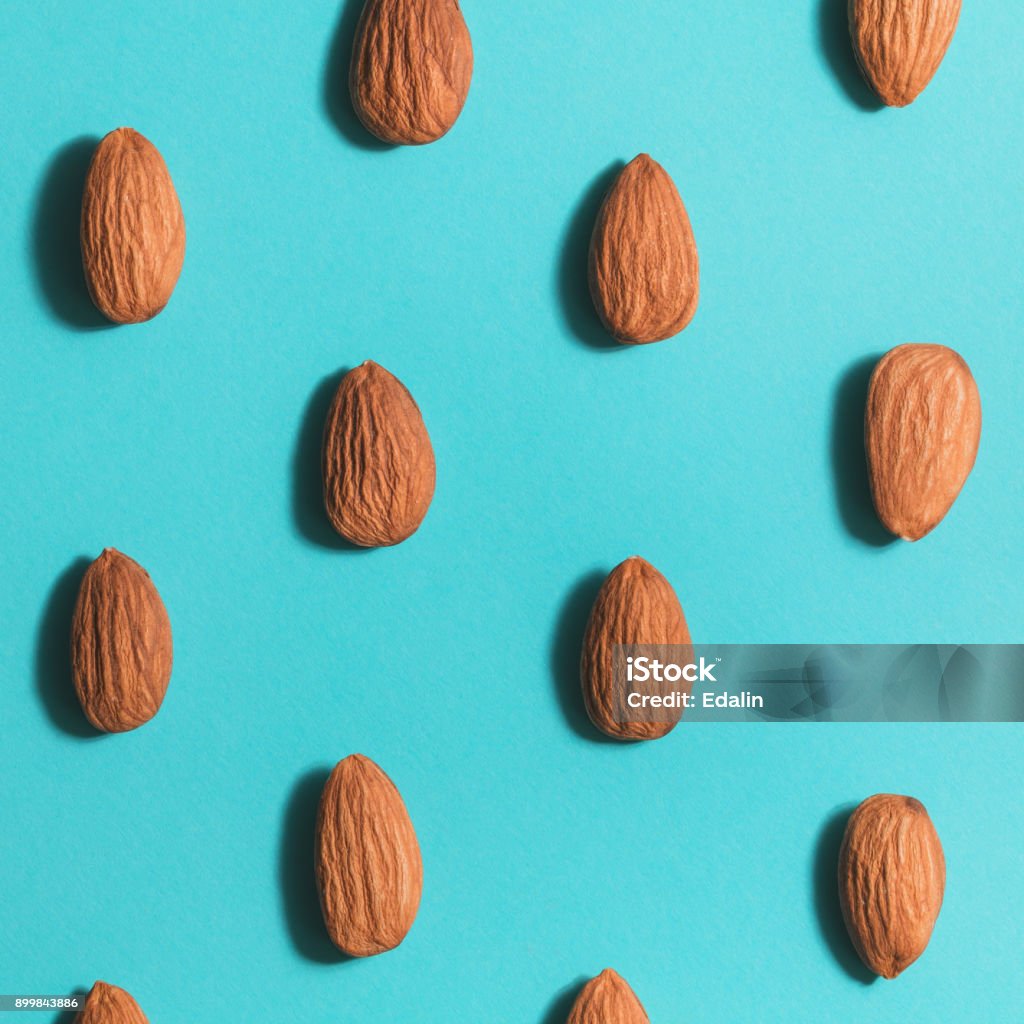 Symmetrical pattern of almonds on blue. Flat lay. Almond Stock Photo