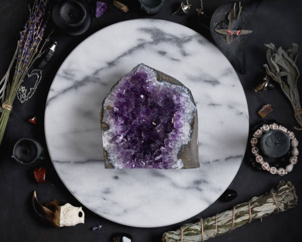 istock Druze of amethyst stone surrounded magic things on the round white marble tray. View from above. 899843930