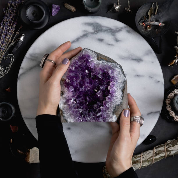 istock The witch is holding amethyst stone surrounded magic things. View from above. 899843946