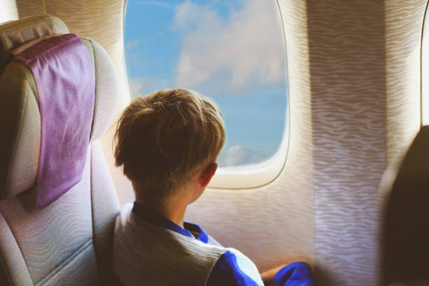 istock little boy travel by plane looking through window 899853406