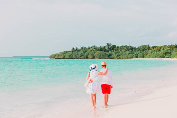 istock happy loving couple walk on beach 899853430