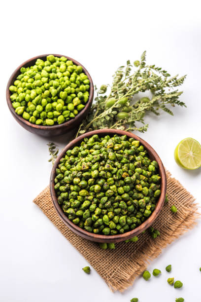 обжаренный свежий зеленый chickpeas или chick peas или harbara на хинди, также известный как cicer с щепоткой соли и чат масала и лимона, популярная закуска - cicer стоковые фото и изображения