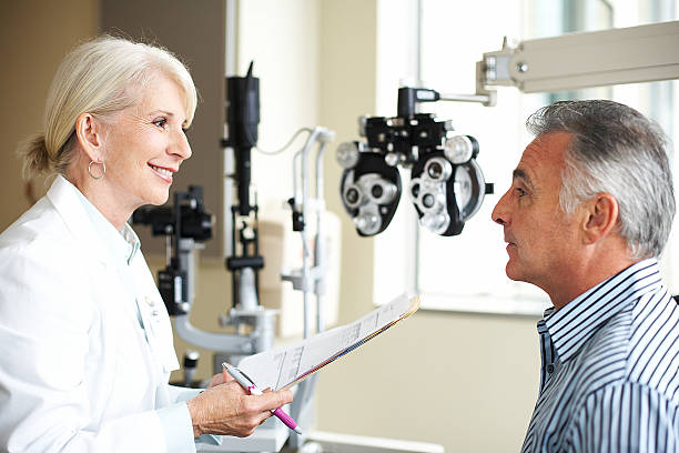 A female opthamologist listens to her patient.  eye care professional stock pictures, royalty-free photos & images