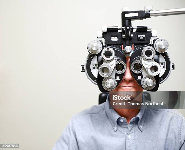 Mature Man Looking Through Phoroptor Stock Photo - Download Image Now - Eye Exam, Optometry, Eye Test Equipment