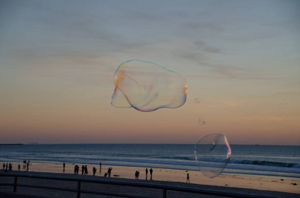 Soap bubbles floating during a sunset near Pacific beach boardwalk, San Diego