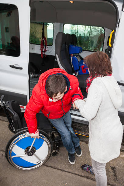 istock A mother helps her handicapped son off the school bus. 899902986
