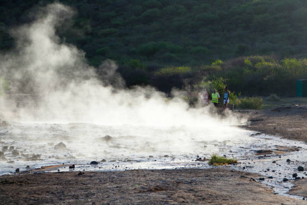 Steaming water at Lake Bogoria, Kenya Lake Bogoria, Kenya - February 10: Tourists watching the steaming water of hot springs at Lake Bogoria in Kenya against the light on February 10, 2013 lake bogoria stock pictures, royalty-free photos & images