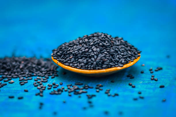 Close up of black sesame seed,Sesamum indicum in a small plate on a wooden surface. stock photo