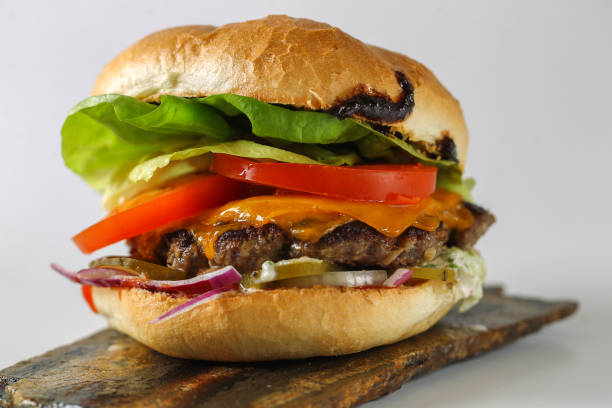 istock Tasty cheese beef burger with lettuce, cheddar, barbecue sauce, tomatoes, 899909510