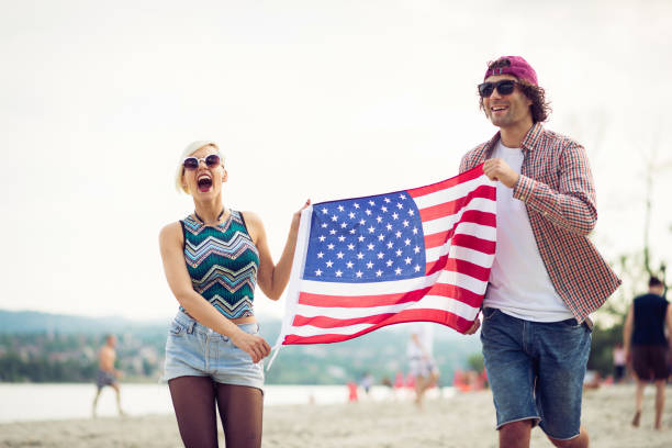 istock Couple on the lake coast with US flag 899910352