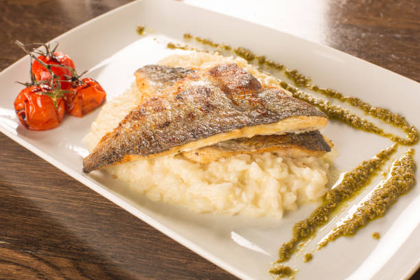 istock Grilled trout with risotto, tomatoes, and pesto 899913688