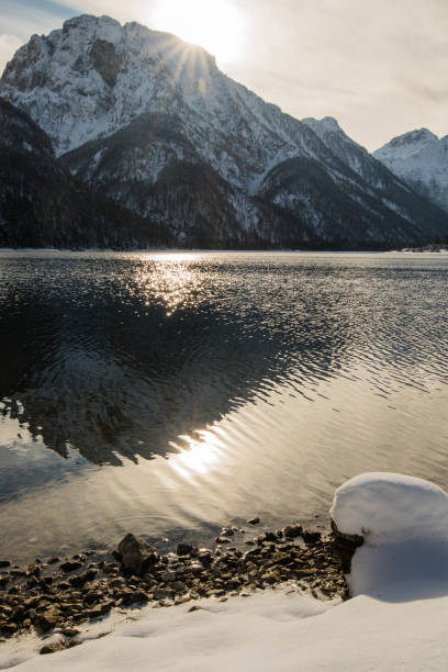 schönen winter verschneite landschaft reflexion über see lago del predil mit isolierten schneebedeckten felsen in den julischen alpen, italien - julian alps mountain lake reflection stock-fotos und bilder