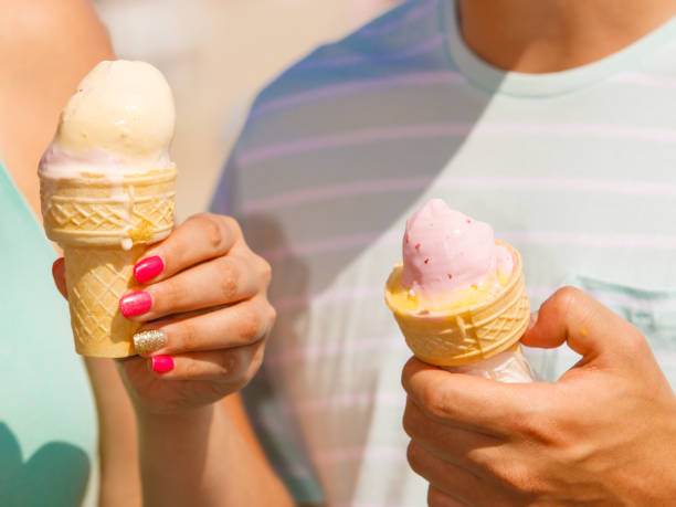 istock Man and woman holding two ice cream 899914134
