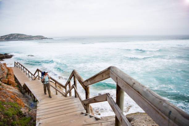 istock Adventurous man hikes on a boardwalk along the coast 899918616