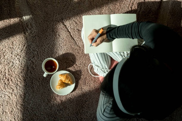 istock girl writing while having croissant and coffee 899923026