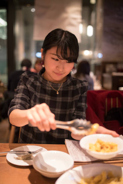 istock Young woman serving pasta at restaurant 899923690