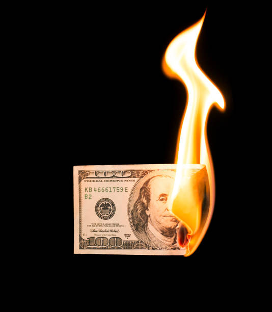 istock a hundred dollars burn in a fire on a black background 899926000