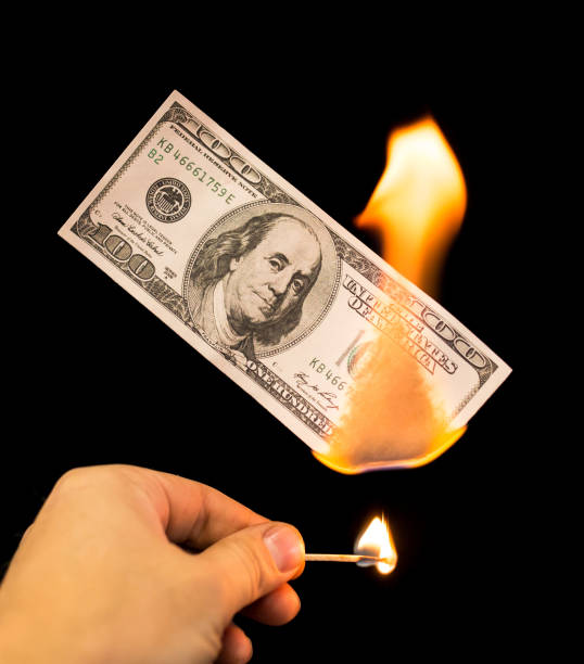 istock a hundred dollars burn in a fire on a black background 899926042