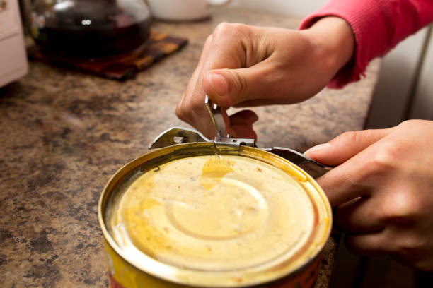 istock Opens canned fish with a can opener 899927380