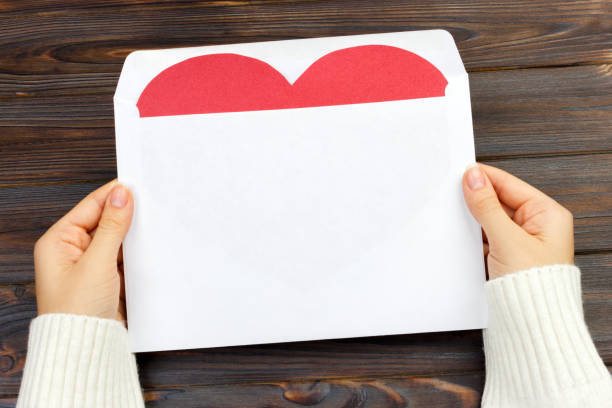 istock Empty postcard in hand with heart. On the wooden table. top view and copy space 899928166