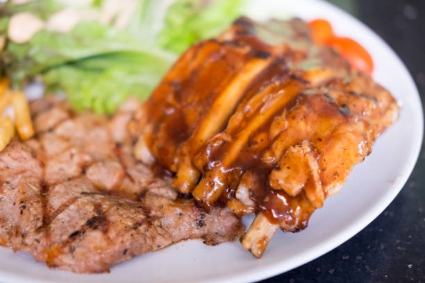 Rib eye steak on white plate, close up