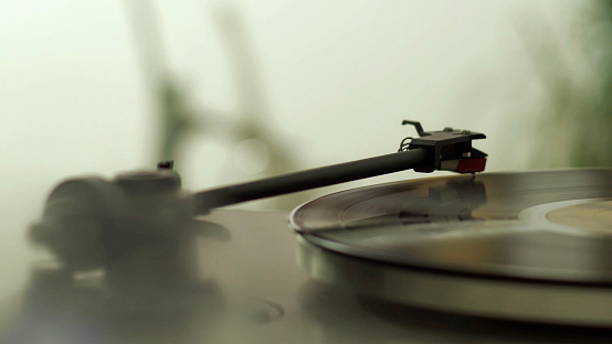 Close up of a record on a vinyl player in a living room. With a very shallow depth of field.