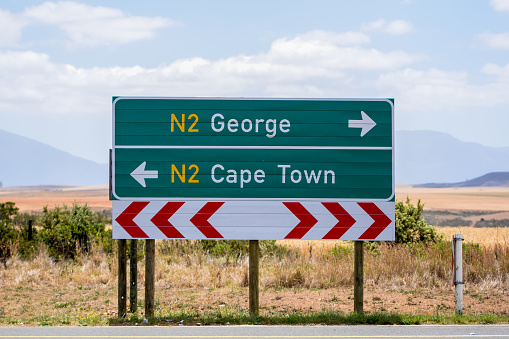 Road sign at the route N2 road in South Africa near Still Bay pointing to Cape Town and George. The N2 is a national route that runs from Cape Town to Ermelo and is the main highway along the ocean.